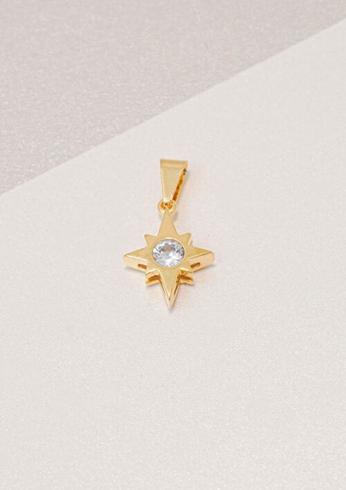 Colgante de oro en forma de estrella, con una piedra preciosa transparente en el centro, elaborado con joyas en oro laminado de 18k.