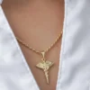 Primer plano de un collar de caduceo de oro usado sobre una camisa blanca de cuello abierto, mostrando la elegancia de Joyas en Oro Laminado 18K.