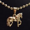 Un collar de oro que presenta el colgante Dije Caballo de un caballo caminando sobre una cadena de cuentas, elaborado con exquisitas joyas en oro laminado de 18k.