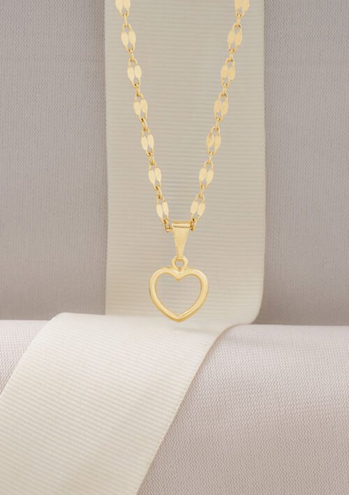 Collar de oro con colgante en forma de corazón “Dije Corazon Silueta” sobre fondo de tela beige claro, con joyas en oro laminado de 18k.