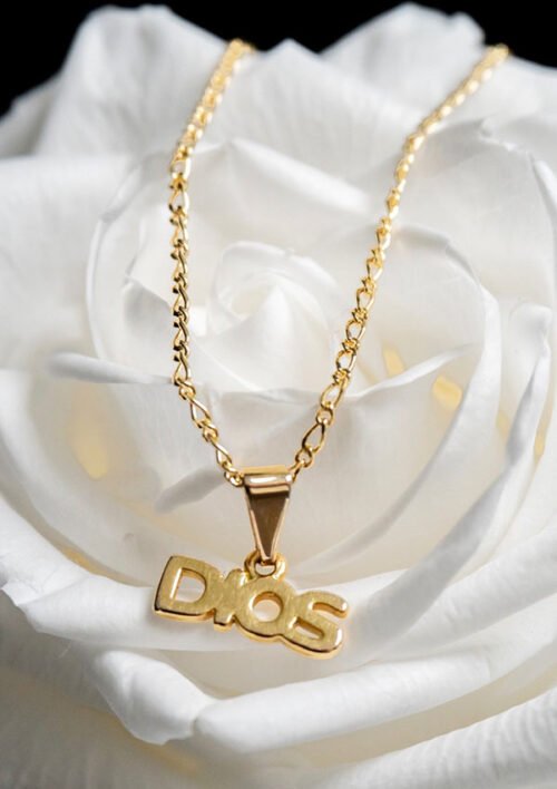 Un collar de oro con un colgante "Dije Dios" descansa sobre una rosa blanca, con joyas en oro laminado de 18k.