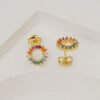 Un par de aretes circulares Aretes Rainbow, oro laminado de 18 quilates con piedras preciosas multicolores, expuestas sobre una superficie blanca.