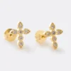 Aretes Cristal Círculo Cristal con forma de cruz de oro adornada con pequeños diamantes sobre fondo liso.