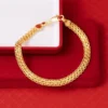 Pulsera de cadena de oro con patrón texturizado, presentada en una caja de joyería roja y blanca.