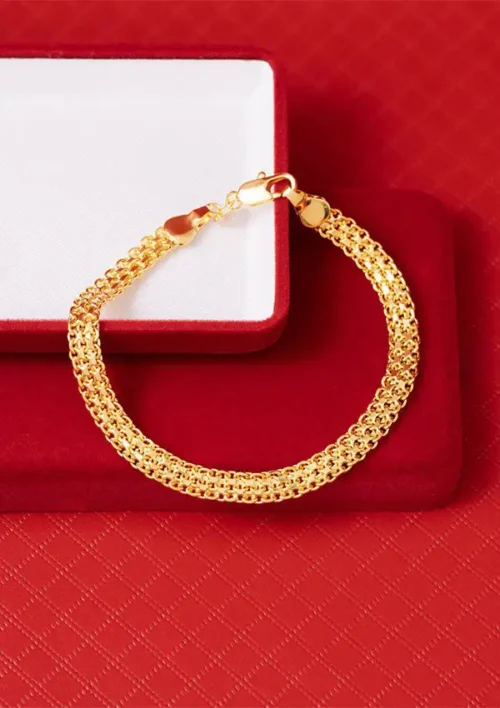 Pulsera de cadena de oro con patrón texturizado, presentada en una caja de joyería roja y blanca.