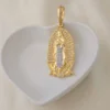 Dije Nuestra Señora de Guadalupe en oro y plata con circonitas, expuesto en plato blanco en forma de corazón sobre fondo claro.